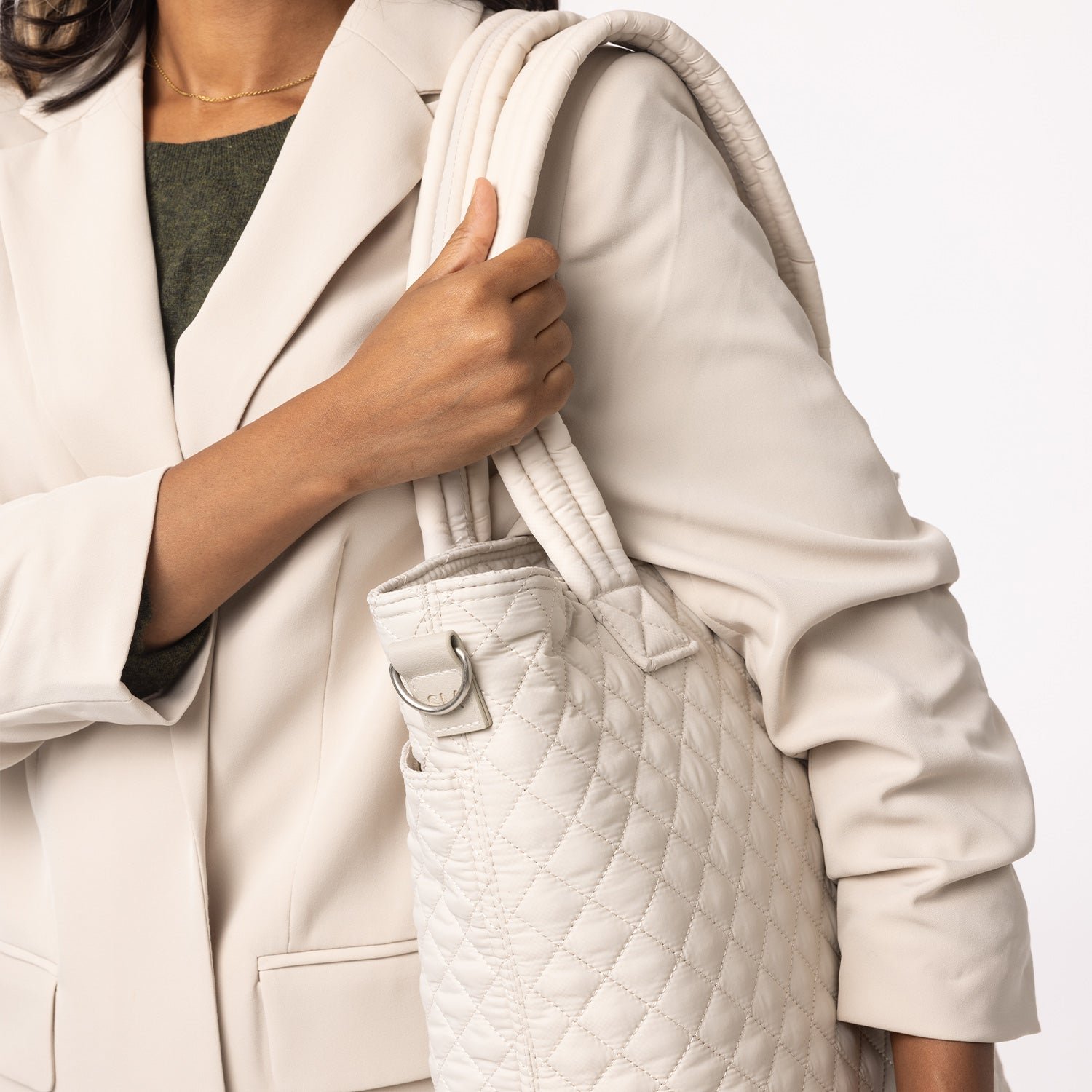 Person holding a large, green quilted tote bag.